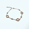 Rose gold bracelet with diamond accents on a white background