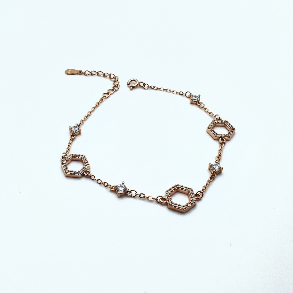 Rose gold bracelet with diamond accents on a white background