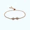 Rose gold bracelet with star-shaped charms on a white background