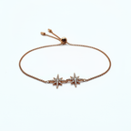 Rose gold bracelet with star-shaped charms on a white background