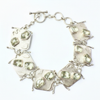 Silver bracelet with green gemstones on a white background