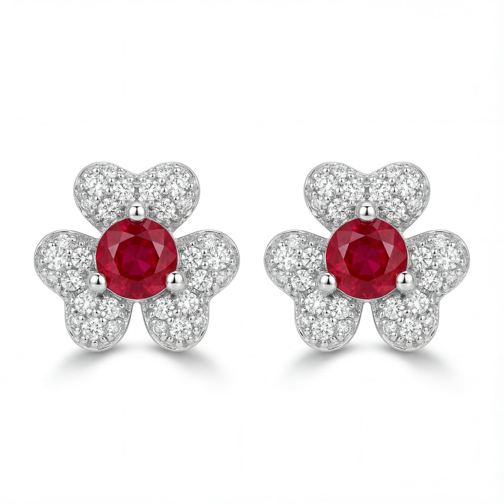 Pair of earrings with red gemstones and silver butterfly designs on a white background