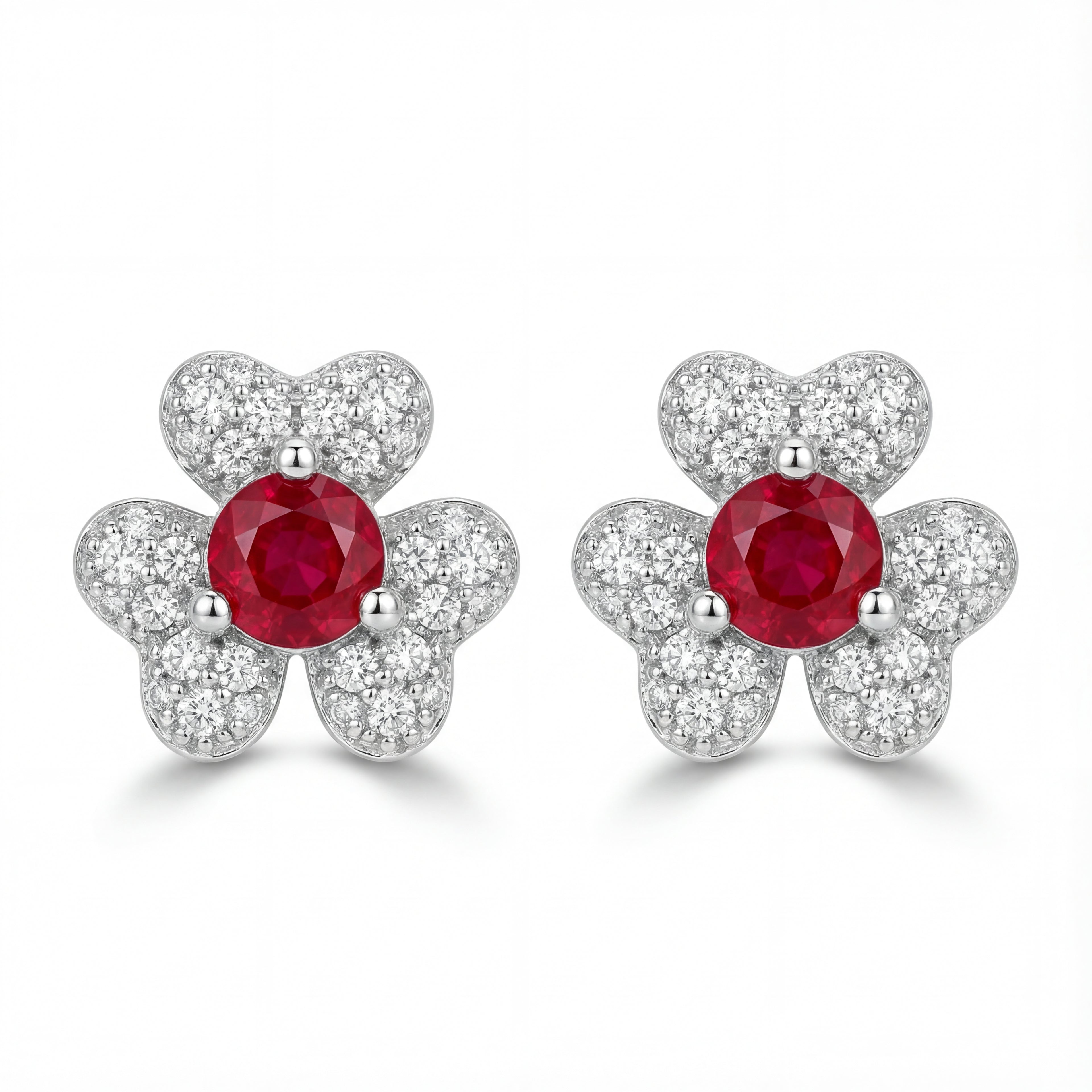 Pair of earrings with red gemstones and silver butterfly designs on a white background