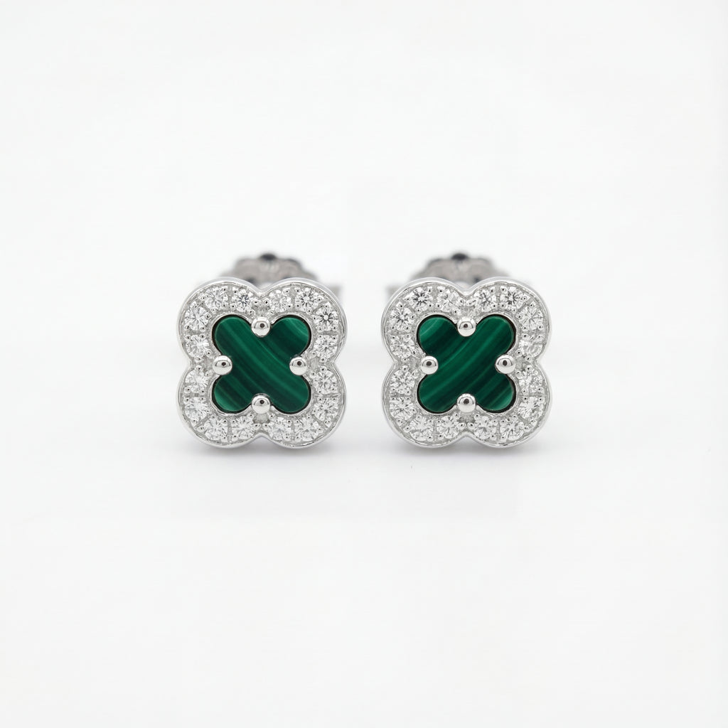 Pair of clover-shaped earrings with green centers and silver borders on a white background