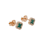 Rose gold earrings with green gemstones on a white background