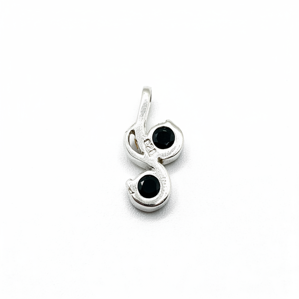 Silver pendant with black gemstones on a white background