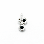 Silver pendant with black gemstones on a white background