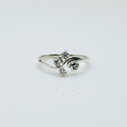 Silver ring with three diamond-like stones on a light gray background