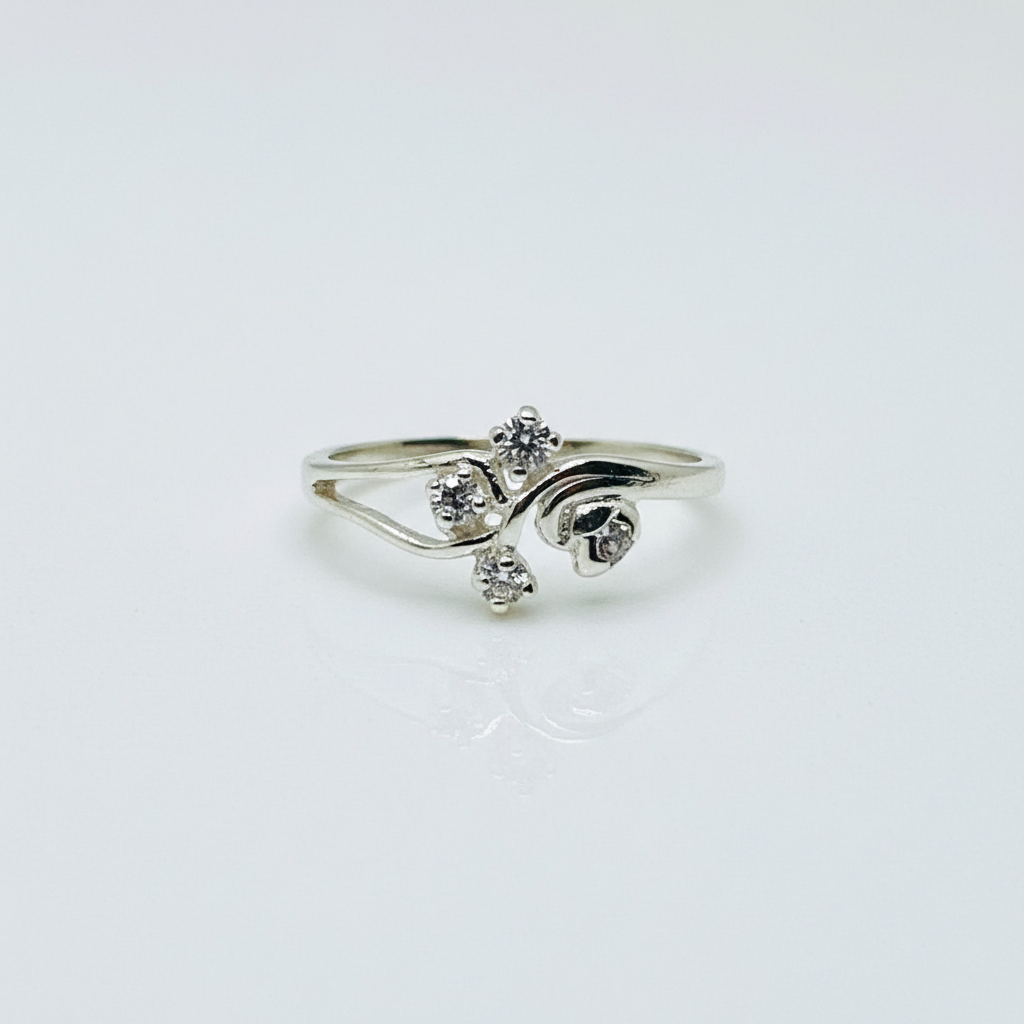 Silver ring with three diamond-like stones on a light gray background