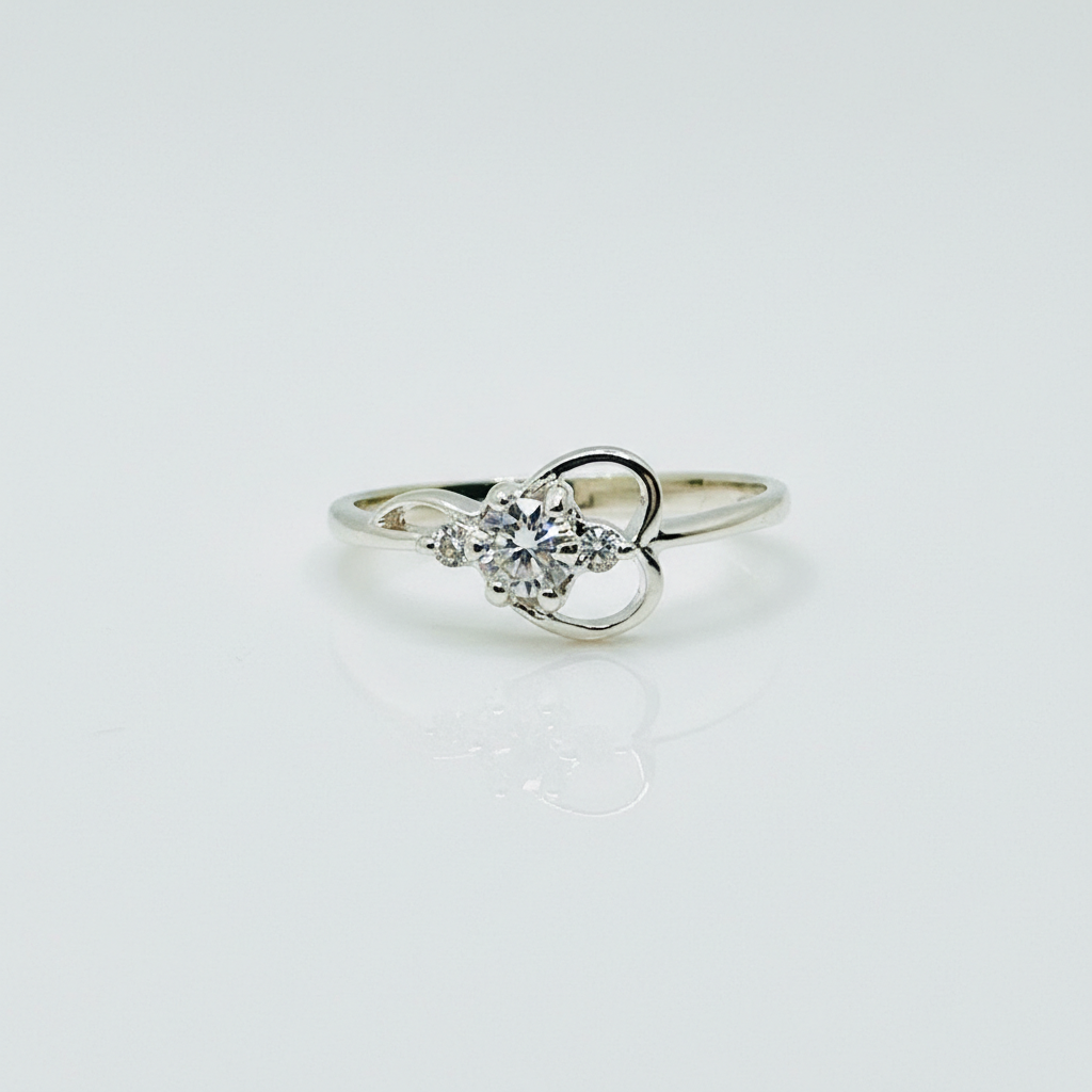 Silver ring with a heart-shaped diamond on a light gray background