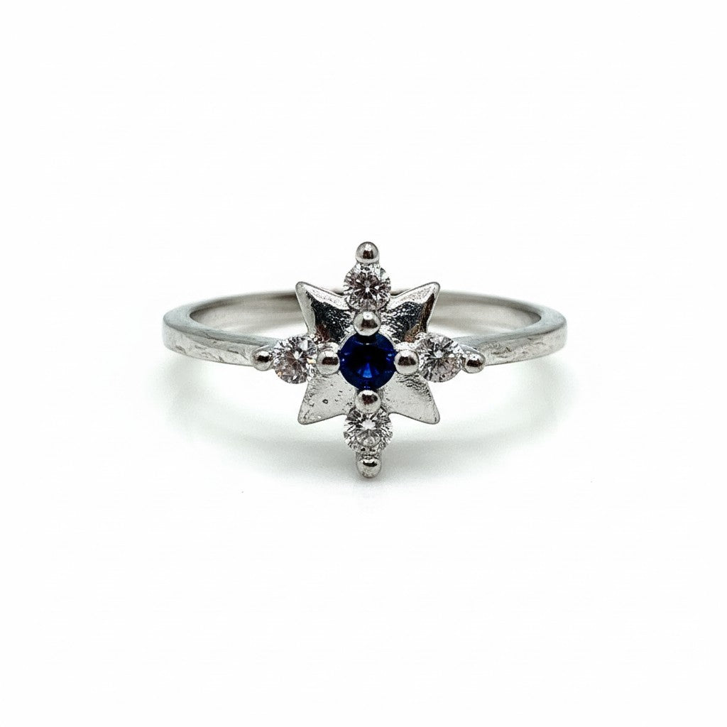 Silver ring with a blue gemstone and smaller diamonds on a white background