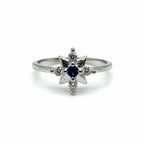 Silver ring with a blue gemstone and smaller diamonds on a white background