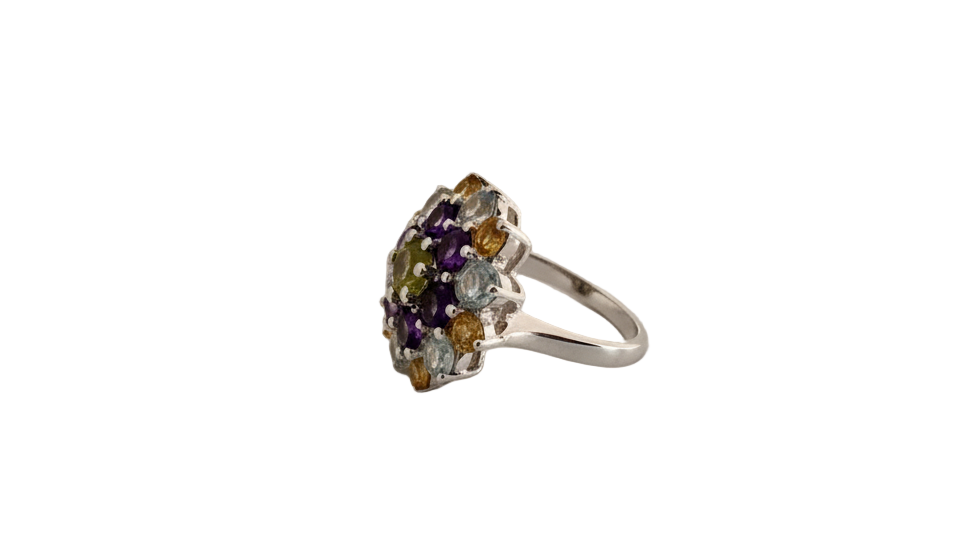 Silver ring with multicolored gemstones on a light gray surface