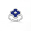 Silver ring with a blue clover-shaped stone and clear stones on a white background