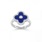Silver ring with a blue clover-shaped stone and clear stones on a white background