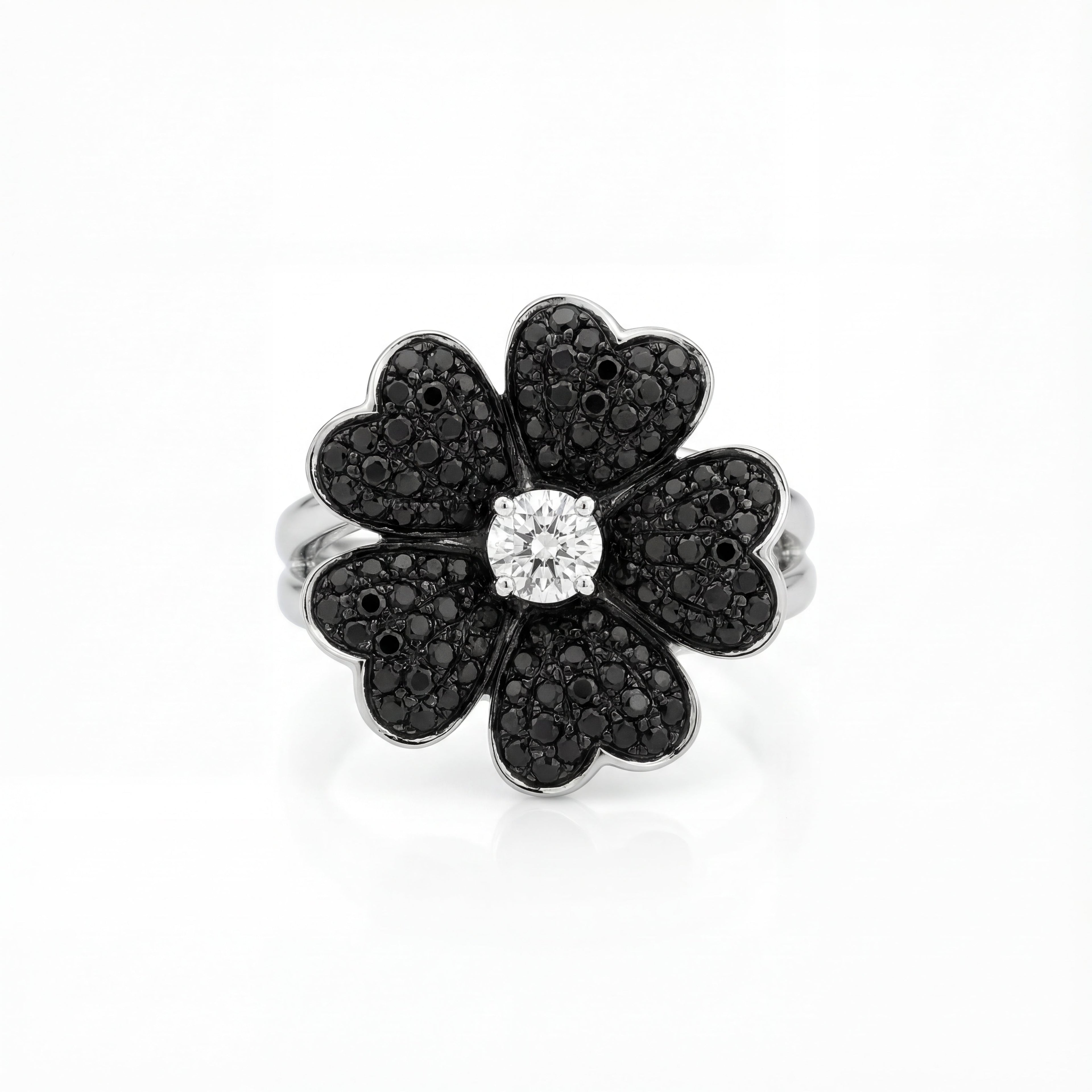 Flower-shaped ring with black and white gemstones on a white background
