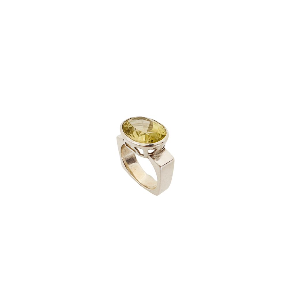 Silver ring with a yellow gemstone on a light gray background