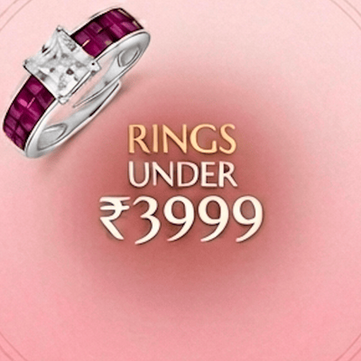 Silver ring with red gemstones on a pink background with text 'Rings Under ₹3999'.